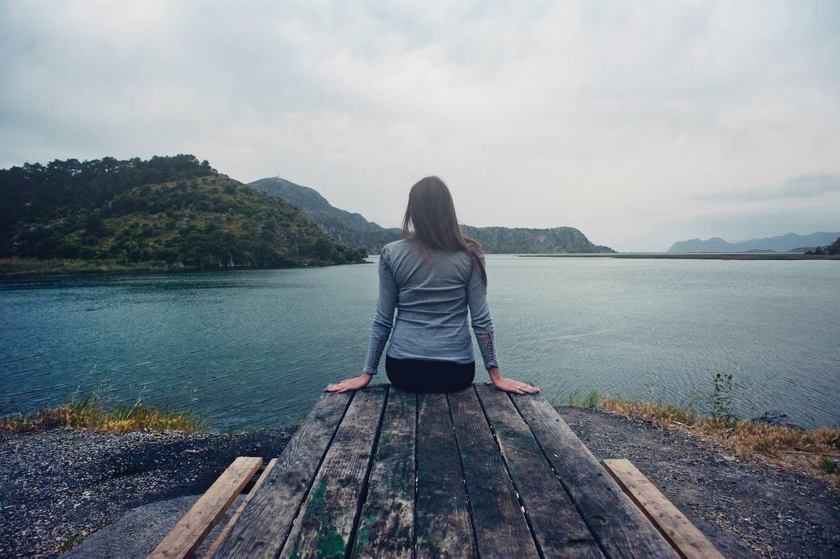 mujer contemplando la vista de un lago