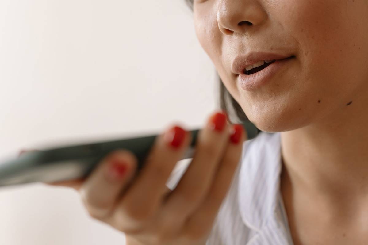 Una persona hablando al microfono de su telefono